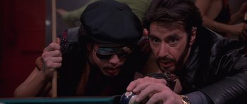 Movie still from “Carlito's Way” (1993), directed by Brian De Palma – Two men are looking at a video game controller; Close Up shot, Over the shoulder angle