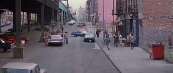 Movie still from “Carlito's Way” (1993), directed by Brian De Palma – A street scene with people walking on the sidewalk and cars driving down the street; Extreme Wide shot, High angle