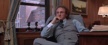 Movie still from “Carlito's Way” (1993), directed by Brian De Palma – A man sitting in a chair in front of a window; Medium shot, Over the shoulder angle