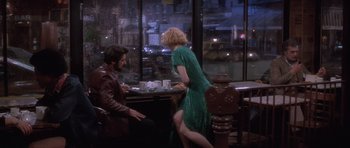 Movie still from “Carlito's Way” (1993), directed by Brian De Palma – A man and a woman sitting at a table in front of a window; Wide shot, Over the shoulder angle