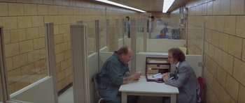Movie still from “Carlito's Way” (1993), directed by Brian De Palma – Two men sitting at a table in a room; Wide shot, Over the shoulder angle