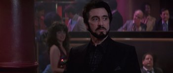 Movie still from “Carlito's Way” (1993), directed by Brian De Palma – A man with a beard and a black suit; Close Up shot, Low angle