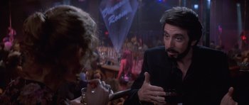 Movie still from “Carlito's Way” (1993), directed by Brian De Palma – A man and a woman are talking in front of a bar; Close Up shot, Over the shoulder angle