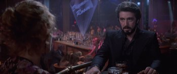 Movie still from “Carlito's Way” (1993), directed by Brian De Palma – A man sitting at a table in front of a bar; Close Up shot, Over the shoulder angle
