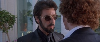 Movie still from “Carlito's Way” (1993), directed by Brian De Palma – A person wearing a suit and sunglasses; Close Up shot, Over the shoulder angle