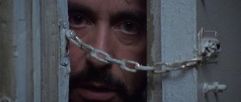 Movie still from “Carlito's Way” (1993), directed by Brian De Palma – A person with a chain around their face; Close Up shot, Low angle