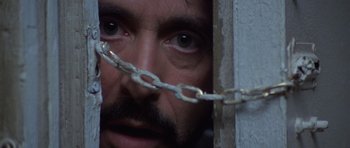 Movie still from “Carlito's Way” (1993), directed by Brian De Palma – A person with a chain around their face; Extreme Close Up shot, Low angle