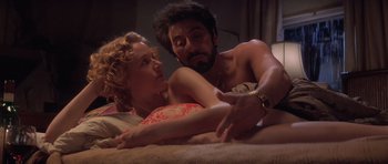 Movie still from “Carlito's Way” (1993), directed by Brian De Palma – A man and a woman laying on a bed together; Medium shot, Low angle