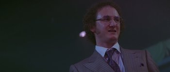 Movie still from “Carlito's Way” (1993), directed by Brian De Palma – A man in a suit and tie with glasses and curly hair; Close Up shot, Low angle