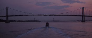 Movie still from “Carlito's Way” (1993), directed by Brian De Palma – A boat traveling across a body of water at night; Extreme Wide shot, High angle