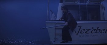 Movie still from “Carlito's Way” (1993), directed by Brian De Palma – A man on a boat in the dark holding a stick; Wide shot, Low angle