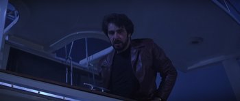 Movie still from “Carlito's Way” (1993), directed by Brian De Palma – A man wearing a leather jacket standing next to a boat; Medium shot, Low angle