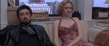 Movie still from “Carlito's Way” (1993), directed by Brian De Palma – A woman sitting on top of a couch next to a window; Medium shot, Low angle