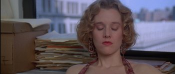 Movie still from “Carlito's Way” (1993), directed by Brian De Palma – A woman with her eyes closed in front of a stack of papers; Close Up shot, High angle