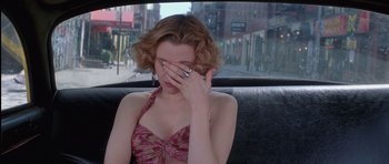 Movie still from “Carlito's Way” (1993), directed by Brian De Palma – A woman sitting in the back of a car covering her eyes; Close Up shot, High angle