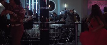 Movie still from “Carlito's Way” (1993), directed by Brian De Palma – A man sitting at a bar drinking a beer; Wide shot, Over the shoulder angle