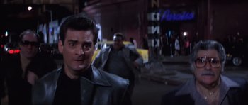 Movie still from “Carlito's Way” (1993), directed by Brian De Palma – A man in a leather jacket walking down a street; Close Up shot, Low angle