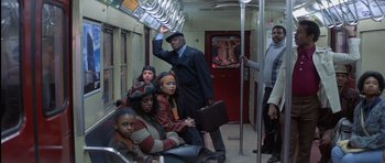 Movie still from “Carlito's Way” (1993), directed by Brian De Palma – A group of people riding on a train; Wide shot, High angle