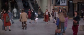 Movie still from “Carlito's Way” (1993), directed by Brian De Palma – A group of people walking down an escalator in a building; Wide shot, High angle
