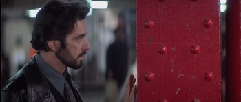 Movie still from “Carlito's Way” (1993), directed by Brian De Palma – A person leaning against a wall; Close Up shot, Over the shoulder angle