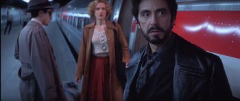 Movie still from “Carlito's Way” (1993), directed by Brian De Palma – A man and a woman standing next to each other on a train; Medium shot, Low angle
