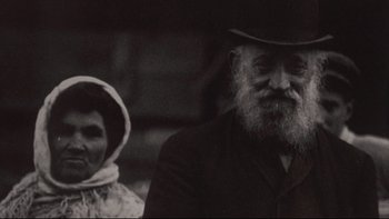 Movie still from “Days of Heaven” (1978), directed by Terrence Malick – An old man and a woman are standing next to each other; Close Up shot, Low angle
