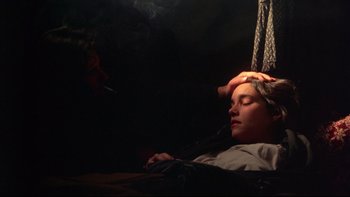 Movie still from “Days of Heaven” (1978), directed by Terrence Malick – A man smoking a cigarette while laying down; Close Up shot, High angle