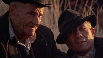 Movie still from “Days of Heaven” (1978), directed by Terrence Malick – Two older men wearing hats and one is looking at the camera; Close Up shot, Low angle