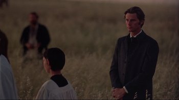 Movie still from “Days of Heaven” (1978), directed by Terrence Malick – A man and a woman standing in a grassy field; Medium shot, Over the shoulder angle