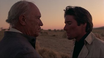 Movie still from “Days of Heaven” (1978), directed by Terrence Malick – Two men standing next to each other on a desert plain; Close Up shot, Low angle