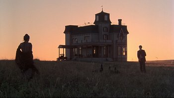 Movie still from “Days of Heaven” (1978), directed by Terrence Malick – An old house in the middle of a grassy field at sunset; Extreme Wide shot, Low angle
