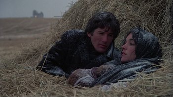 Movie still from “Days of Heaven” (1978), directed by Terrence Malick – A man and a woman laying in a pile of hay; Medium shot, Low angle