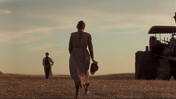 Movie still from “Days of Heaven” (1978), directed by Terrence Malick – A group of people walking across a dry grass field; Wide shot, Low angle