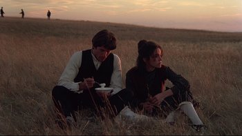 Movie still from “Days of Heaven” (1978), directed by Terrence Malick – A man and a woman sitting in a field; Medium shot, High angle
