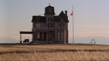 Movie still from “Days of Heaven” (1978), directed by Terrence Malick – An old house with a flag flying in the background; Extreme Wide shot, Low angle