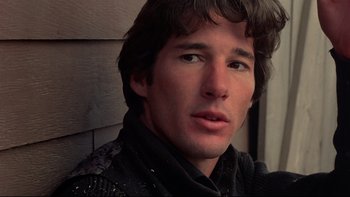 Movie still from “Days of Heaven” (1978), directed by Terrence Malick – A person wearing a black jacket; Close Up shot, Over the shoulder angle