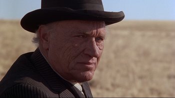 Movie still from “Days of Heaven” (1978), directed by Terrence Malick – An older man wearing a hat and a suit; Close Up shot, Low angle