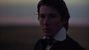 Movie still from “Days of Heaven” (1978), directed by Terrence Malick – A person wearing a suit and tie; Close Up shot, Over the shoulder angle