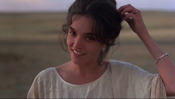 Movie still from “Days of Heaven” (1978), directed by Terrence Malick – A beautiful young lady smiling for the camera; Close Up shot, Over the shoulder angle