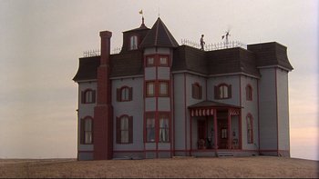 Movie still from “Days of Heaven” (1978), directed by Terrence Malick – An old style house with a very tall chimney; Extreme Wide shot, Low angle
