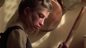 Movie still from “Days of Heaven” (1978), directed by Terrence Malick – A young woman is looking down at a pan; Close Up shot, Low angle