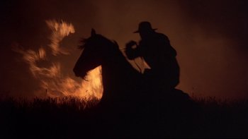 Movie still from “Days of Heaven” (1978), directed by Terrence Malick – A man riding a horse through a field at night; Wide shot, Low angle