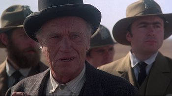 Movie still from “Days of Heaven” (1978), directed by Terrence Malick – An old man wearing a hat and a suit; Close Up shot, Over the shoulder angle