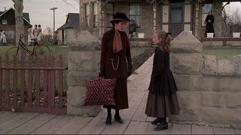 Movie still from “Days of Heaven” (1978), directed by Terrence Malick – A woman and a little girl standing next to each other on a sidewalk; Wide shot, Over the shoulder angle