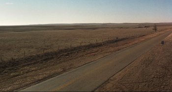 Movie still from “Cast Away” (2000), directed by Robert Zemeckis – An empty road in the middle of a dry field; Extreme Wide shot, High angle