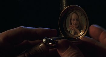 Movie still from “Cast Away” (2000), directed by Robert Zemeckis – A person is holding a mirror with a picture in it; Extreme Close Up shot, High angle