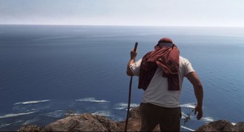 Movie still from “Cast Away” (2000), directed by Robert Zemeckis – A man standing on top of a mountain with a stick; Wide shot, High angle