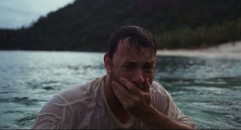 Movie still from “Cast Away” (2000), directed by Robert Zemeckis – A man sitting in the water covering his mouth with his hand; Close Up shot, Low angle