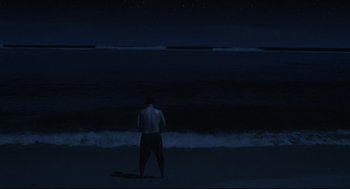 Movie still from “Cast Away” (2000), directed by Robert Zemeckis – A man standing on the beach at night; Extreme Wide shot, Low angle