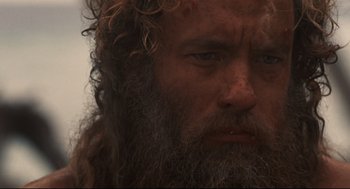 Movie still from “Cast Away” (2000), directed by Robert Zemeckis – A person with long hair and a beard; Close Up shot, Low angle